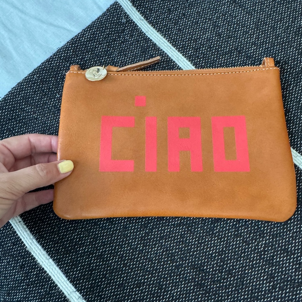 Clare V wallet clutch in brown leather with CIAO written on it in bright red.